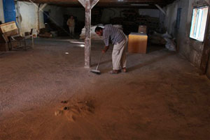 A Palestinian worker sweeps out the empty storeroom of a U.N. food distribution center in Gaza City.