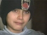 A Palestinian girl cries while her mother lies dying on the floor.