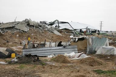 The Silmiya shelter in front of their bombed house.