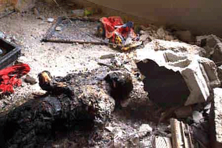 The burned remains of a Palestinian boy lay amidst toys in a house destroyed by Israeli soldiers in the Jenin refugee camp Saturday, April 13, 2002.
