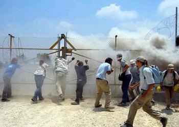 Demonstrators protesting Israel&rsquo;s construction of a separation barrier through Palestinian land are tear gassed.