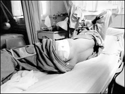 A boy with a bandage on his left buttock lies in a hospital bed:
Mohammad Nada, 17, will need a nerve graft to regain full mobility in his left leg.