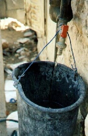 Filling a bucket with water.